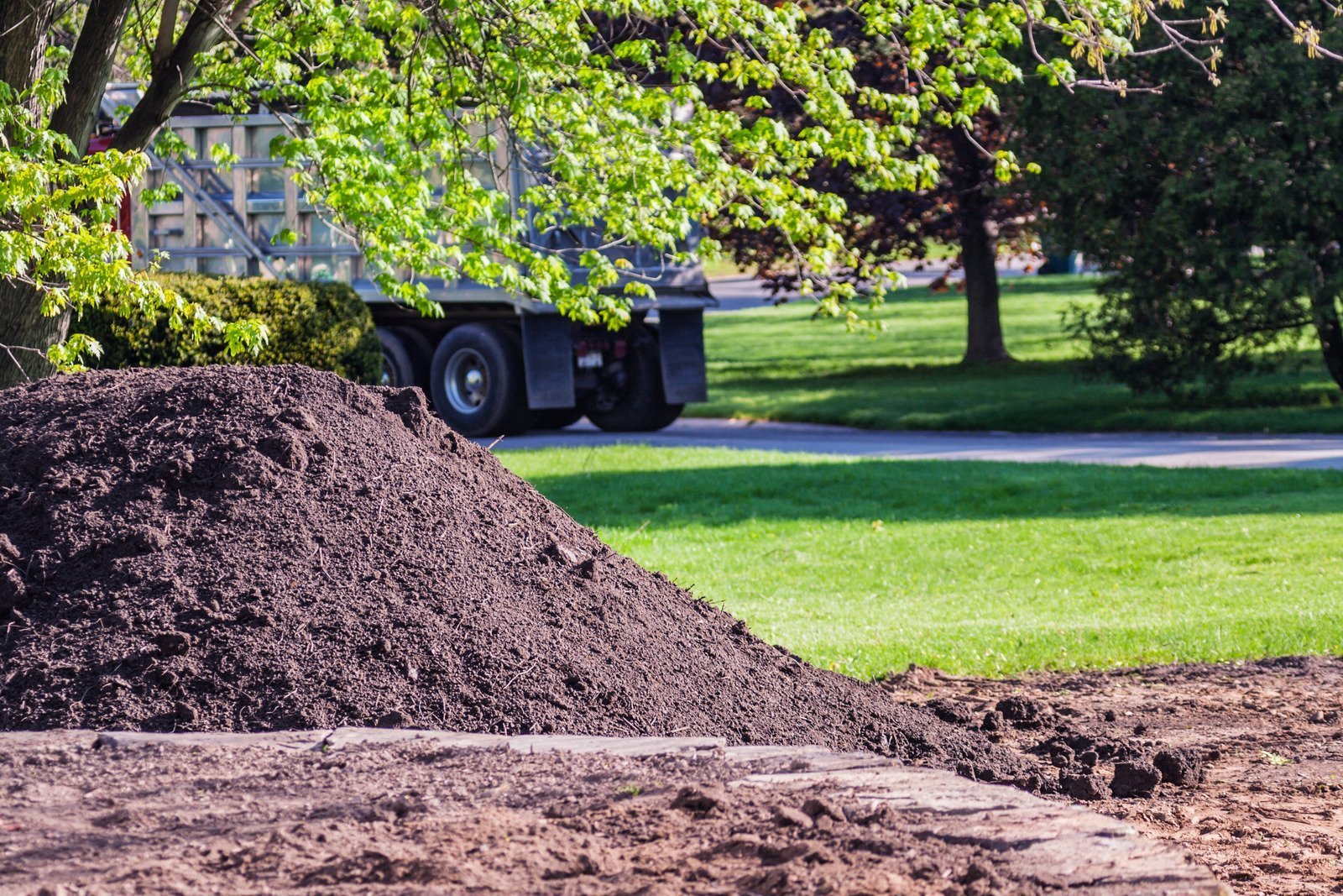 Topdressing machine spreading screened soil on a new lawn