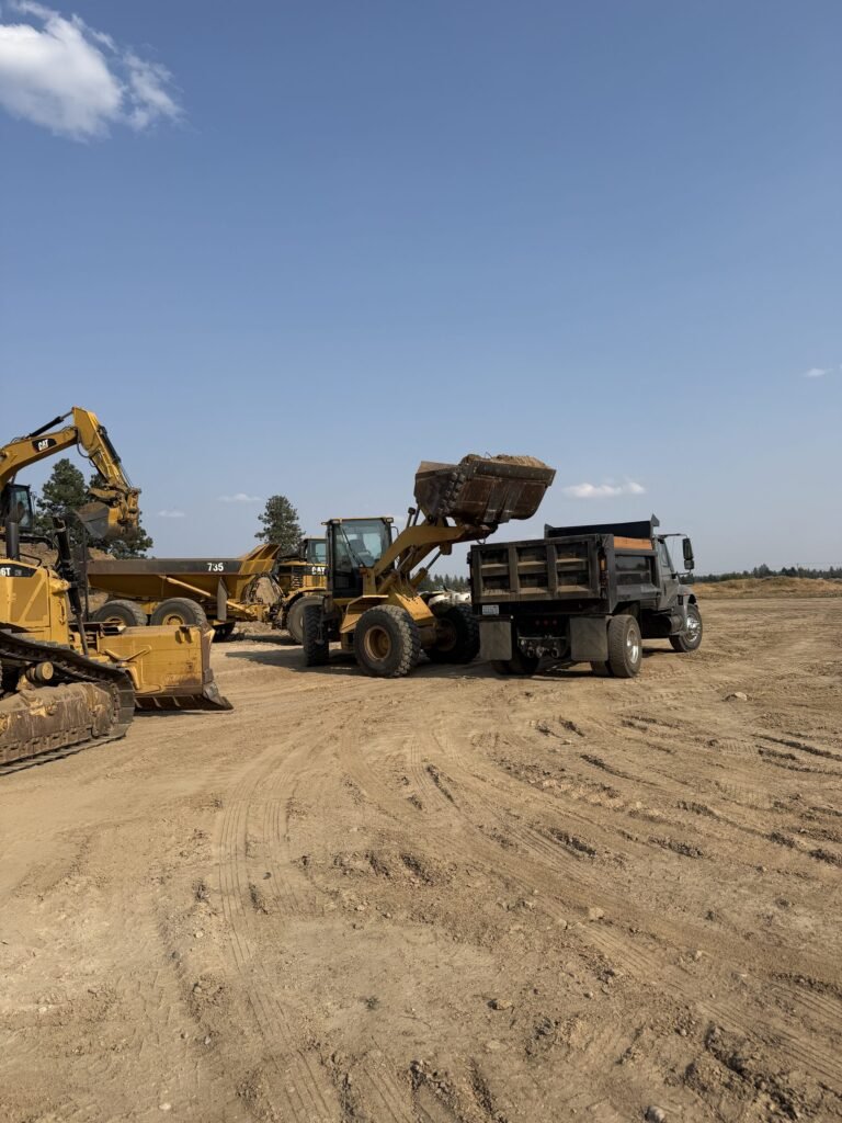 Loader and dump truck working bulk material at the Millsap Supply yard