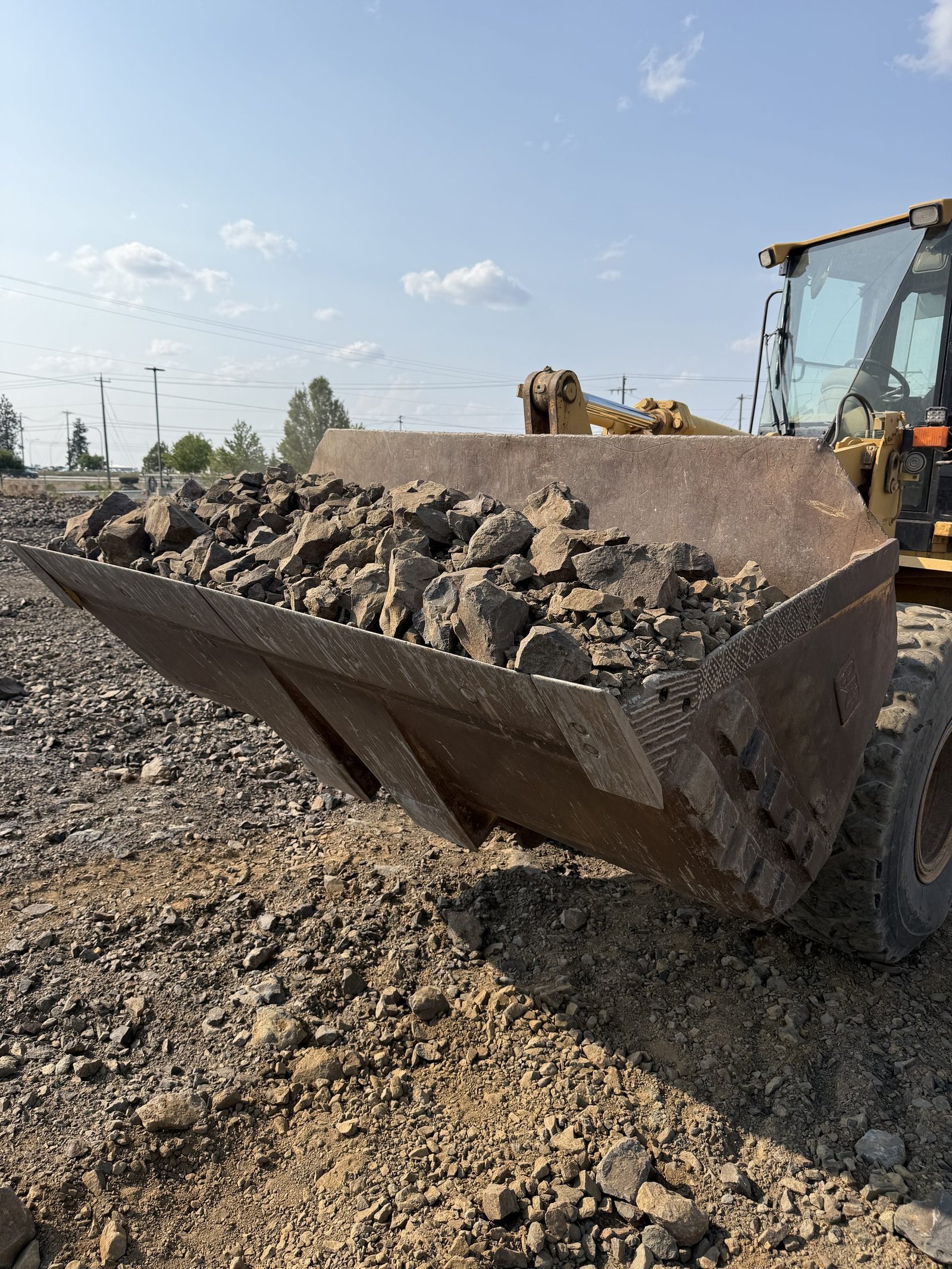 Wheel loader bucket filled with bulk landscape material at the supply yard